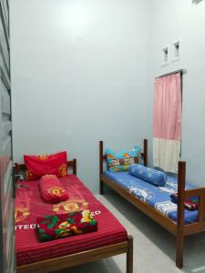 a bedroom with two twin beds and a window at Rome Residence Sibolga Pandan in Halangan