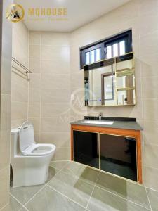 a bathroom with a toilet and a sink and a mirror at 25A Cửu Long in Ho Chi Minh City