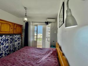 een slaapkamer met een bed met een paarse sprei bij Le 5éme Penthouse cosy with sea view in Sousse