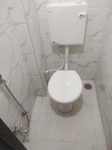 a white toilet in a bathroom with marble walls at Hotel Solis Stay in Solapur
