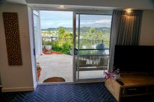 uma sala de estar com uma porta de vidro deslizante para uma varanda em 3 Waters Guest Accommodation em Gold Coast