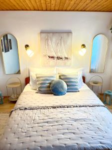 een slaapkamer met een bed met 2 lampen en 2 spiegels bij Olivier house in Zaglav