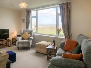 a living room with a couch and chairs and a window at Sea Drift in Walcott