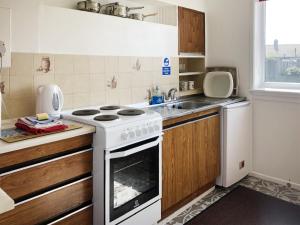 een keuken met een wit fornuis en een wastafel bij Sea Drift in Walcott