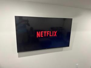 a television screen with the words netflix on a wall at Tee's Haven in Calgary