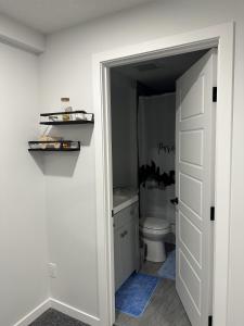 a bathroom with a toilet and a white door at Tee's Haven in Calgary