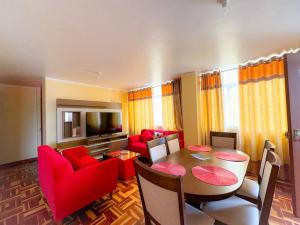 uma sala de estar com uma mesa e cadeiras vermelhas em Acogedor y lindo Departamento en estreno em Lima