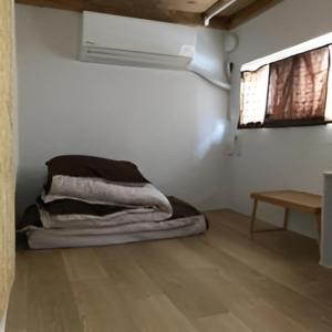 a room with a bed in the corner of a room at AVAHOUSE アバハウス in Miyako Island