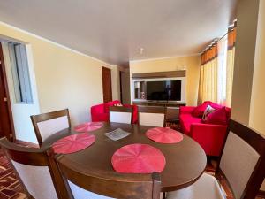 ein Wohnzimmer mit einem Tisch und einem roten Sofa in der Unterkunft Acogedor y lindo Departamento en estreno in Lima