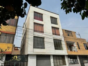 ein hohes weißes Gebäude mit Seitenfenstern in der Unterkunft Acogedor y lindo Departamento en estreno in Lima