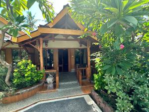 un ingresso in legno in una casa con piante di Sunny Rose Bungalows Gili Air a Gili Air