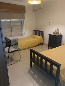 sypialnia z 2 łóżkami i krzesłem w obiekcie La josefina w mieście Villa María