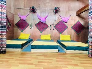 a room with three beds and pink and yellow pillows at Du Gia Field View Homestay in Làng Cac