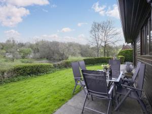 a patio with a table and chairs on a lawn at Pine Lodge - Uk46679 in Highley