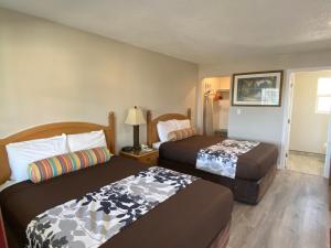 a hotel room with two beds in a room at Travelers Inn Eugene University in Eugene