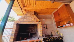 een stenen open haard in een keuken met een houten plafond bij Hostel Loli in Puerto Iguazú