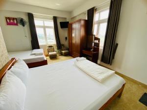 - une chambre avec 2 lits dans une pièce avec fenêtres dans l'établissement Nhat Hoang Hotel, à Hô-Chi-Minh-Ville
