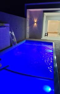 uma piscina azul num quarto com um lavatório em Mar Doce Lar em Guaratuba