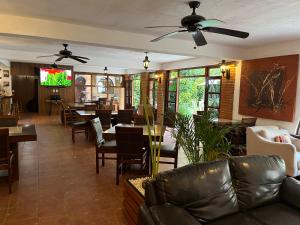 a restaurant with tables and chairs and a ceiling fan at Hotel Hacienda Ventana del Cielo in Tepoztlán