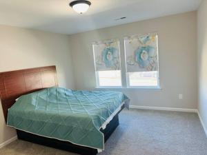 1 dormitorio con 1 cama y 2 ventanas en Entire home in Statesville, NC en Statesville