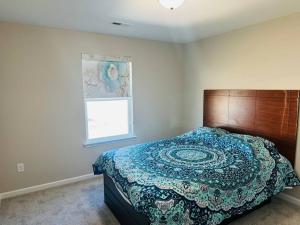 1 dormitorio con 1 cama con cabecero de madera y ventana en Entire home in Statesville, NC en Statesville