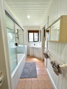 a bathroom with a shower and a tub and a sink at Spacious 5 BR Family Home with free WIFI & AC pet friendly in Bundaberg