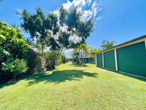 a yard with a building and a tree at Spacious 5 BR Family Home with free WIFI & AC pet friendly in Bundaberg