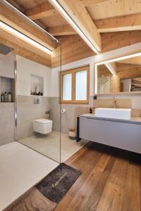 ein Badezimmer mit einer Badewanne, einem Waschbecken und einem Spiegel in der Unterkunft Chalet Capucchione in Les Diablerets
