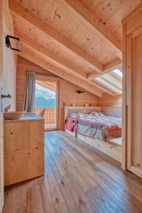 una camera da letto in stile baita di tronchi con letto e finestra di Chalet Capucchione a Les Diablerets