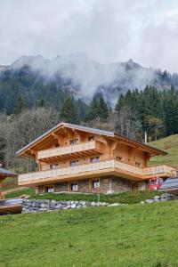ein großes Holzhaus mit einem Berg im Hintergrund in der Unterkunft Chalet Capucchione in Les Diablerets