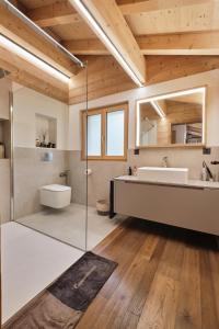 ein Badezimmer mit einer Badewanne, einem Waschbecken und einem Spiegel in der Unterkunft Chalet Capucchione in Les Diablerets