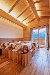 ein Schlafzimmer mit einem Bett in einem Zimmer mit einem großen Fenster in der Unterkunft Chalet Capucchione in Les Diablerets