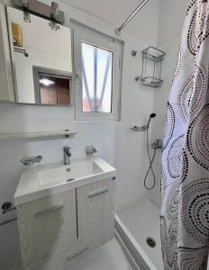 y baño con lavabo, espejo y ducha. en Casa by Hokkum Studios, en Kokkari