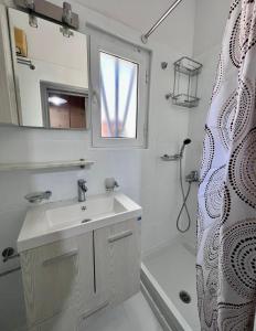 a bathroom with a sink and a mirror and a shower at Casa by Hokkum Studios in Kokkari +6 photos