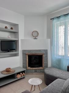 sala de estar con sofá y chimenea en Casa by Hokkum Studios, en Kokkari