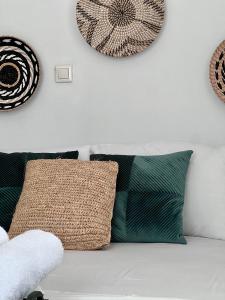 Sofá blanco con almohadas en una pared blanca en Casa by Hokkum Studios, en Kokkari
