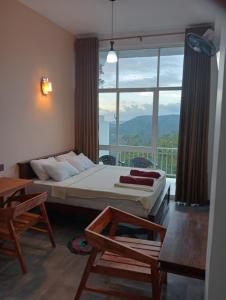 a bedroom with a bed and a large window at Rosenka haputhale in Haputale