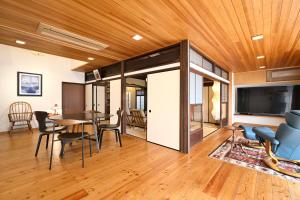 a living room with a table and chairs and a tv at Kyoto Fushimi Sutekichi Private Hotel in Fushimi