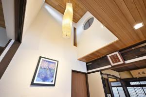 a hallway with white walls and wood ceilings at Kyoto Fushimi Sutekichi Private Hotel in Fushimi