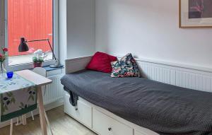 a bedroom with a bed with a lamp and a window at Cozy Apartment In Frjestaden With Wifi in Färjestaden