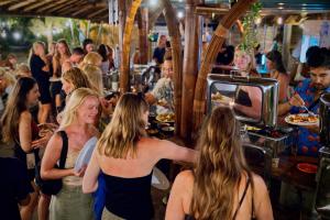 een groep mensen die rond een bar staan bij Begadang in Gili Air