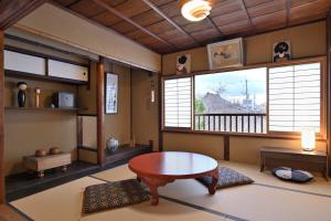 a living room with a table and a window at Kyoto Fushimi Sutekichi Private Hotel in Fushimi