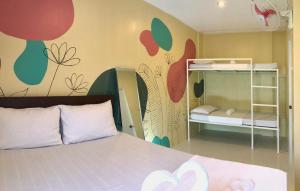 1 dormitorio con 1 cama con un mural de flores en la pared en Chill Out Hostel, en Boracay