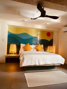 a bedroom with a bed with a painting on the wall at Happiness Hostel Boracay in Boracay