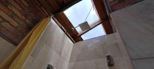 a bathroom with a shower with a window at Cabaña Lato_puzhio in Chordeleg