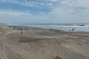 eine Gruppe von Menschen, die am Strand stehen in der Unterkunft 8 Beach Suite w/pool by Madrigera in La Libertad