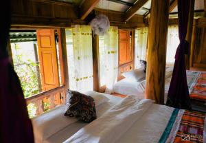 a bedroom with two beds and two windows at Pù Luông Happy Home in Hương Bá Thước