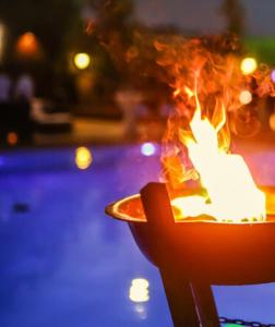 Un fuoco che brucia in un vaso vicino a una piscina di Recanto Natural - Rock In Rio All Inclusive a Rio de Janeiro