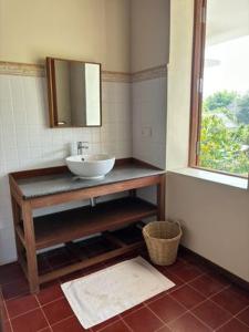 a bathroom with a sink and a mirror at La maison bleue BTB in Phumĭ Kâmpóng Âmpĭl