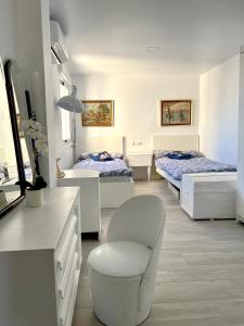 Habitación con 2 camas y una silla. en Rare find! Skyline view-Modern 6 bed 2 bath flat in the heart of Málaga en Málaga